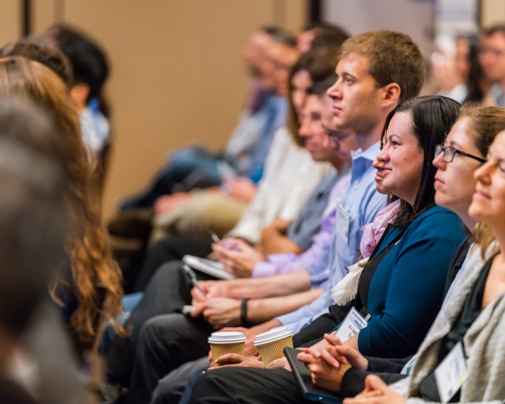 Side view of a row of people seated in the audience